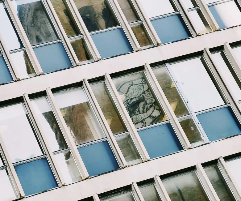 Construction workers hang from the side of a newly constructed building.